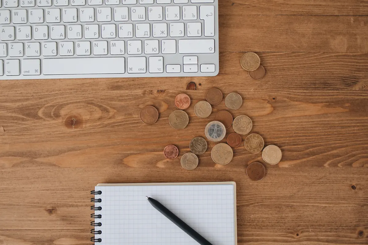 Pièces de monnaie et carnet de notes posés près d'un clavier