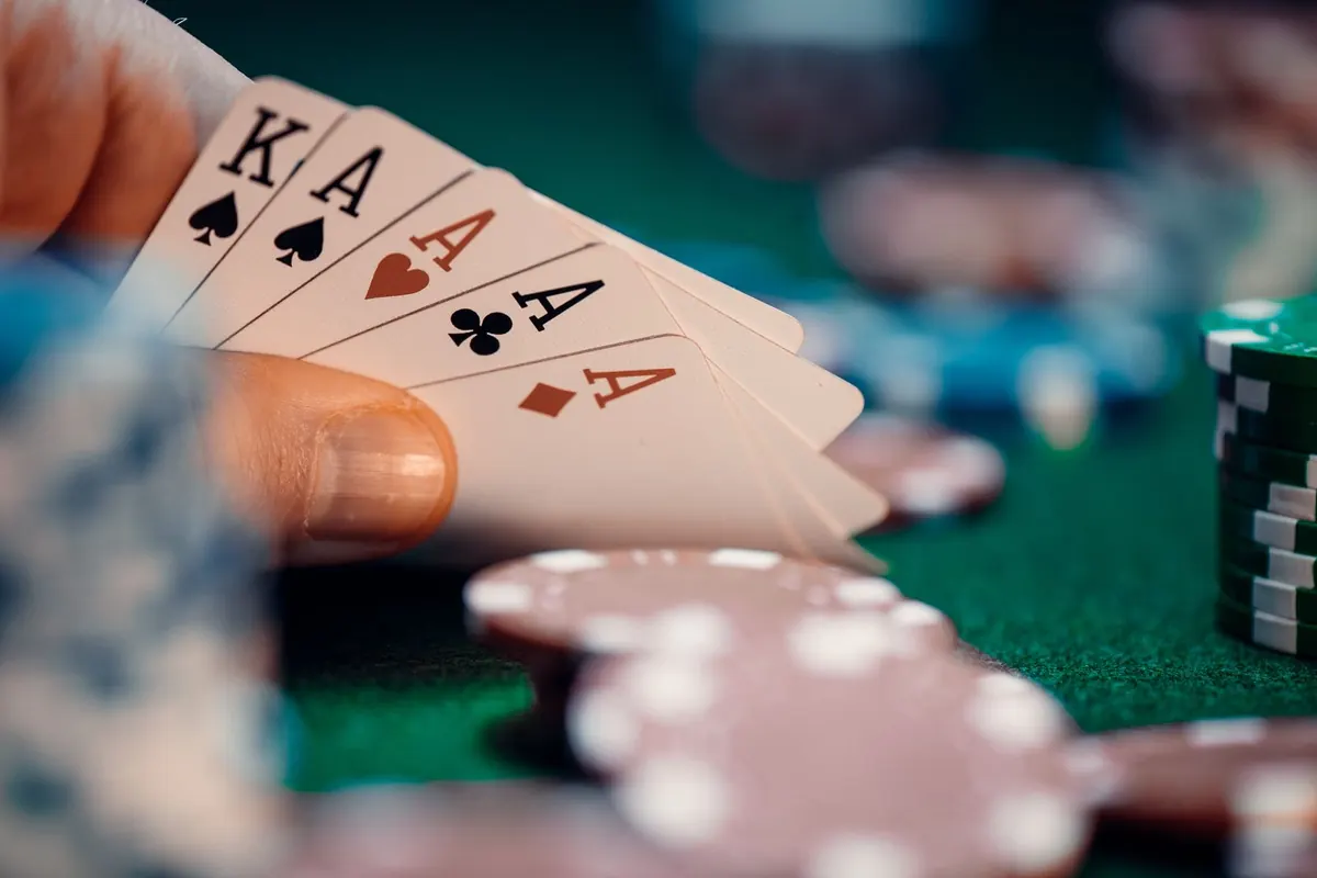 Joueur de poker qui regarde sa paire d'as au-dessus de piles de jetons